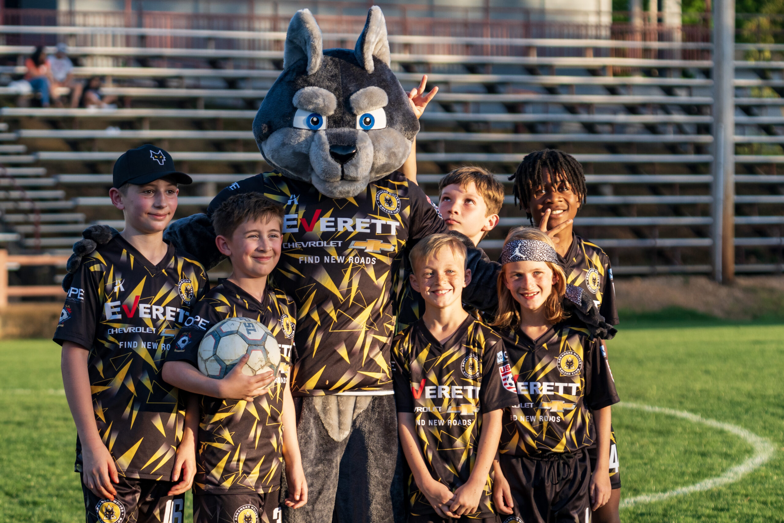 Young Arkansas Wolves players with the Wolves mascot