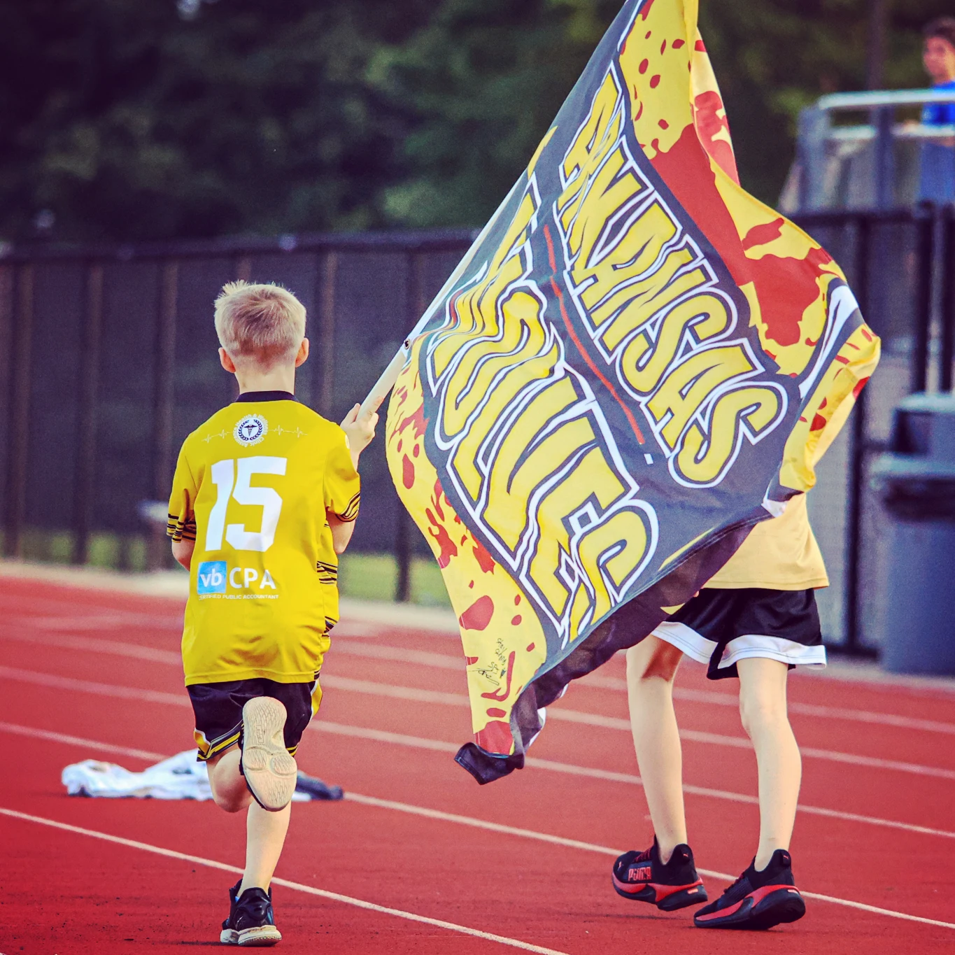 Young Arkansas Wolves supporters carrying a Wolves flag