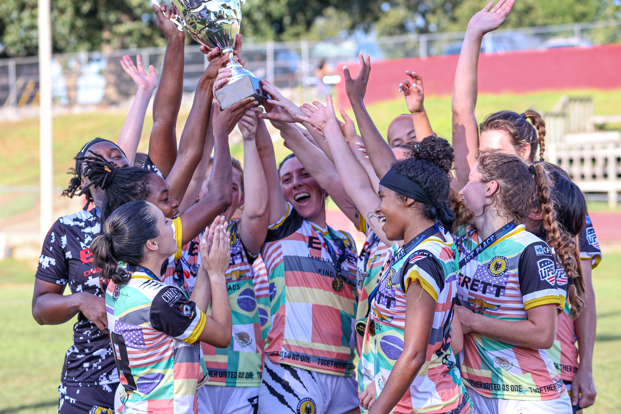 Arkansas Wolves women's team lifting a trophy